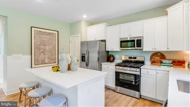 a kitchen with a sink a stove a refrigerator cabinets and a window
