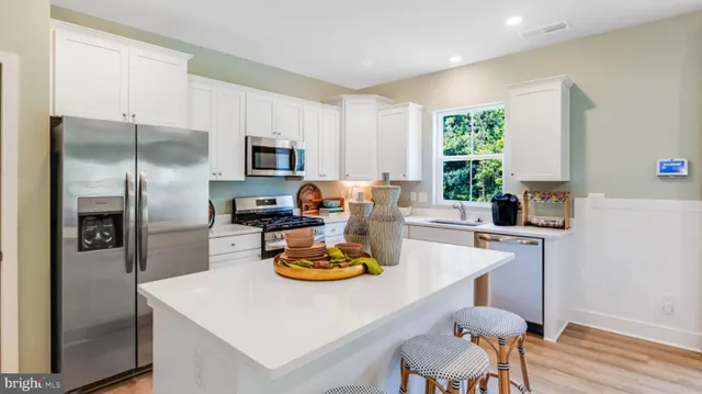 a kitchen with a refrigerator and a stove top oven