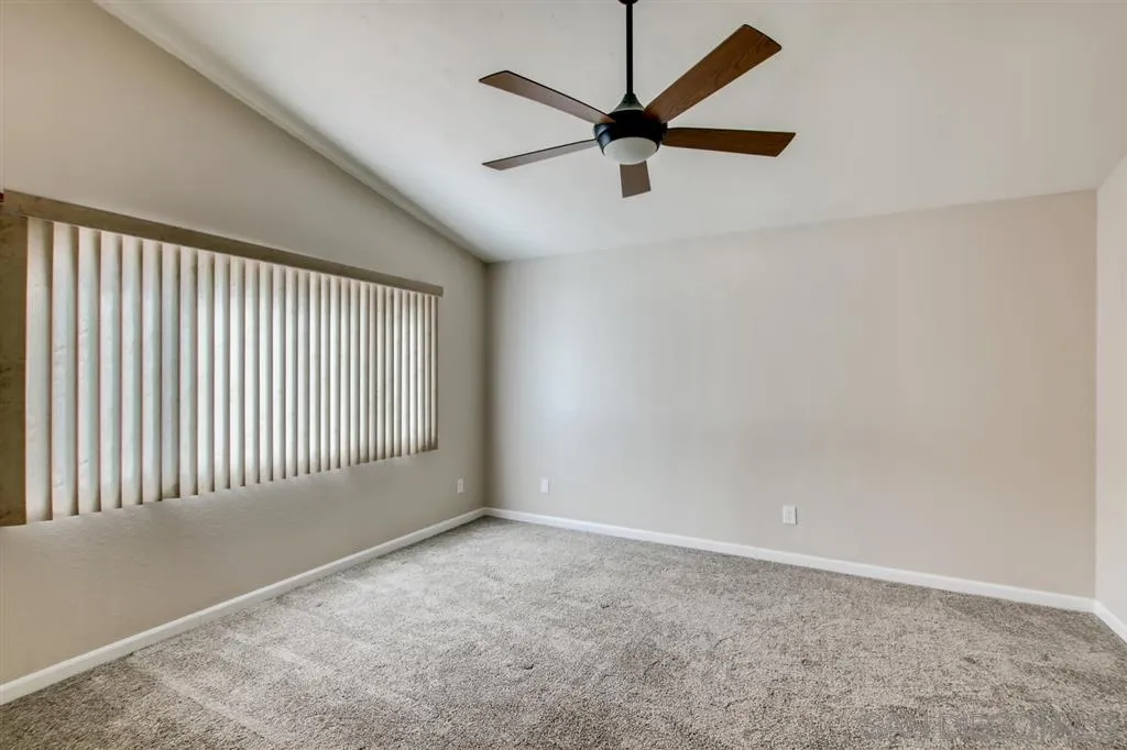 10411 Cadwell Road Santee, CA 92071 - Photo 14 of 25 an empty room with a ceiling fan and windows