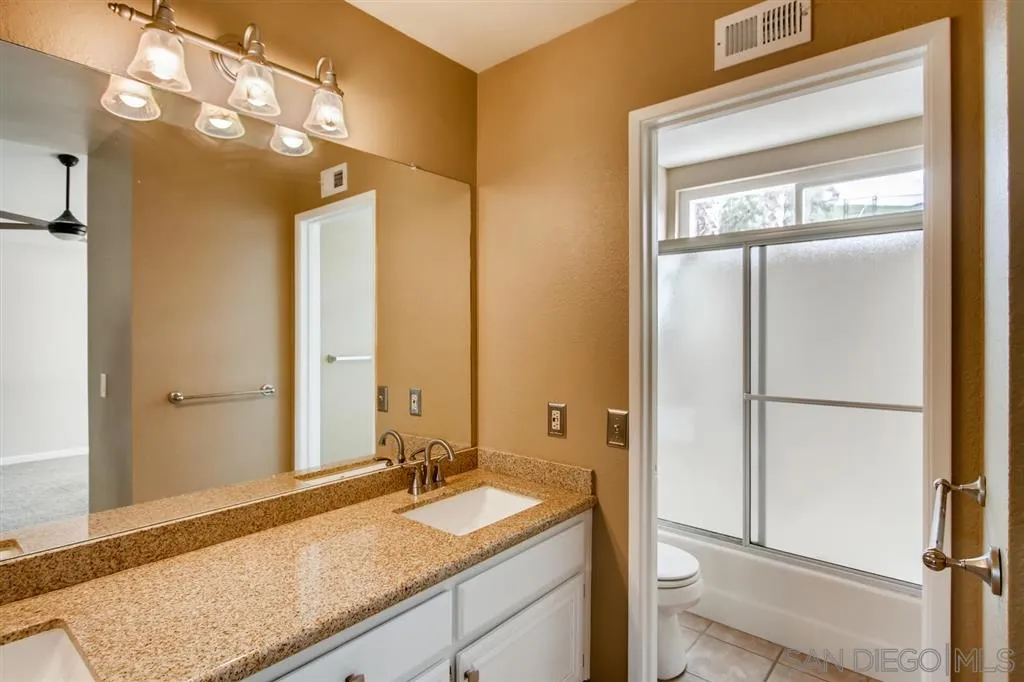 10411 Cadwell Road Santee, CA 92071 - Photo 17 of 25 a bathroom with a granite countertop sink mirror and vanity