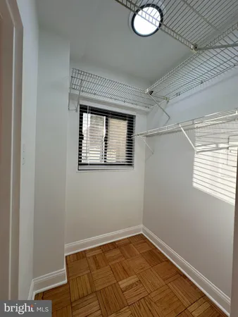 a view of a hallway with wooden floor and a window