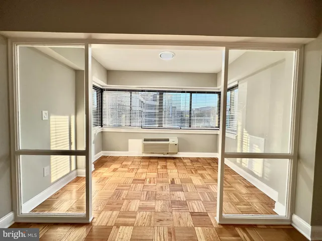 view of an empty room with a floor to ceiling window and a rug