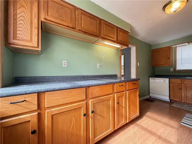 a kitchen with granite countertop wooden cabinets and a wooden floor