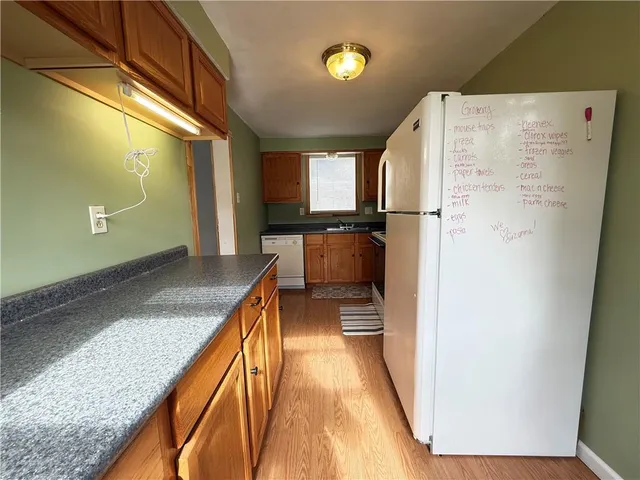a kitchen with granite countertop cabinets stainless steel appliances and a large window