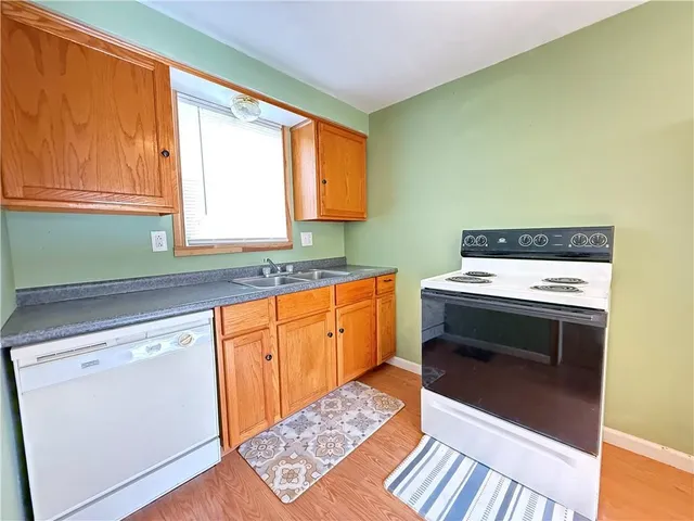 a kitchen with sink a refrigerator and wooden cabinets