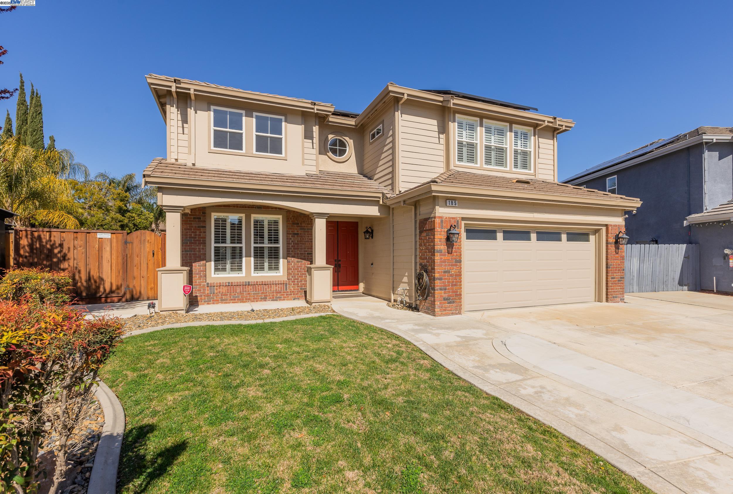 a front view of a house with a yard and wooden fence