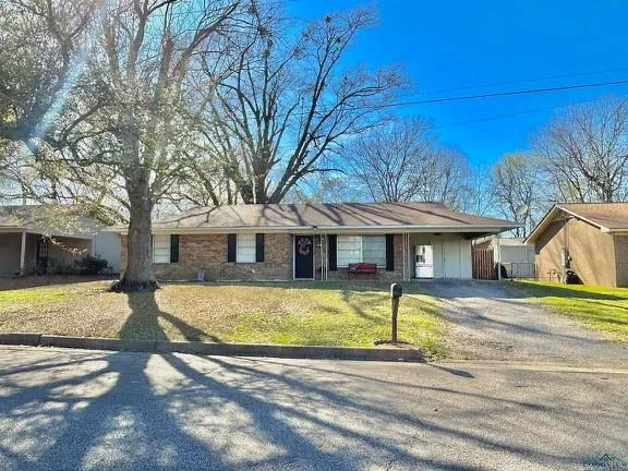 a view of a house with a big yard and large tree