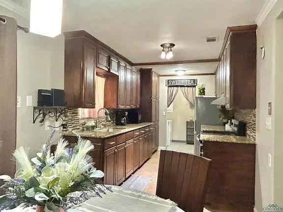 a large kitchen with kitchen island granite countertop a sink stove and refrigerator
