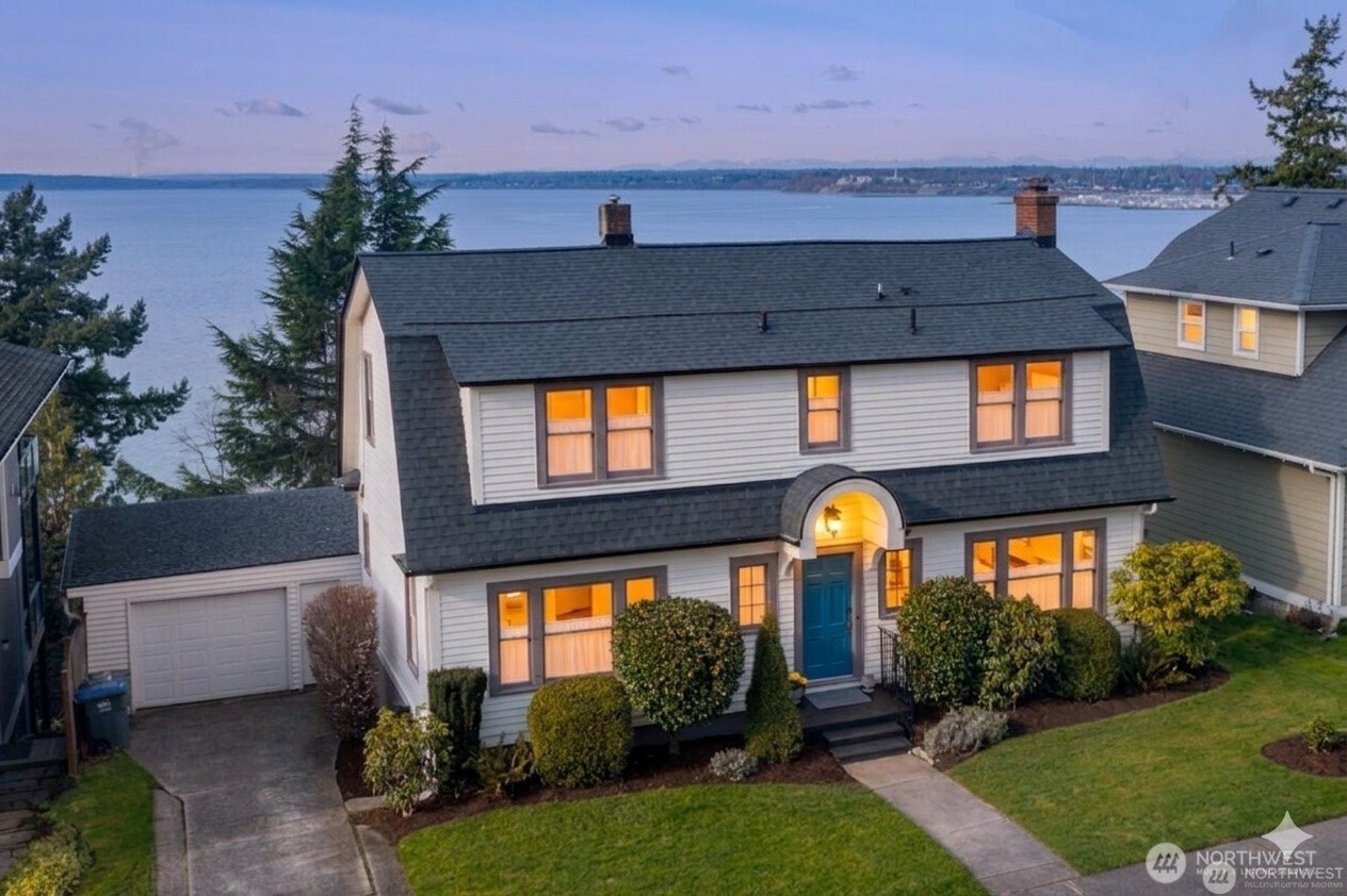 a front view of a house with a yard and a garden