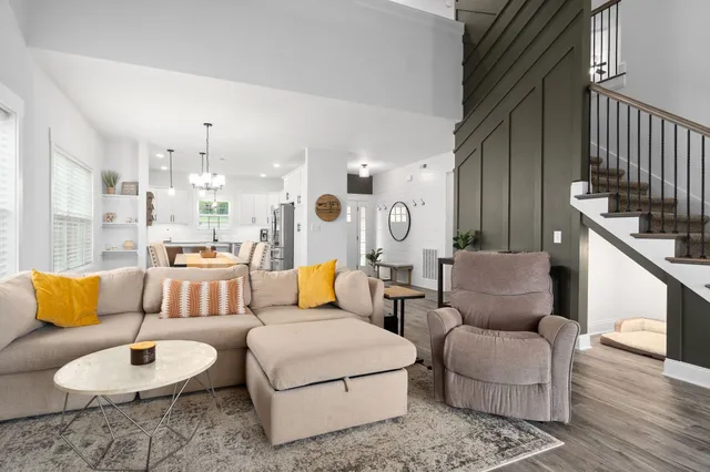 a living room with furniture and a dining table with wooden floor