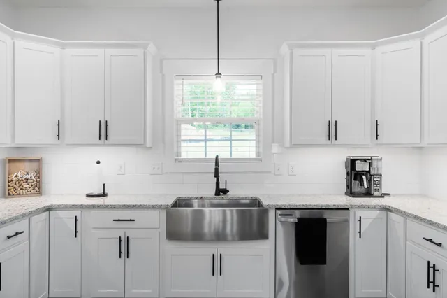 a kitchen with cabinets appliances a sink and a window