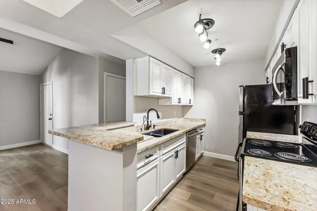 a kitchen with stainless steel appliances granite countertop a sink stove and refrigerator