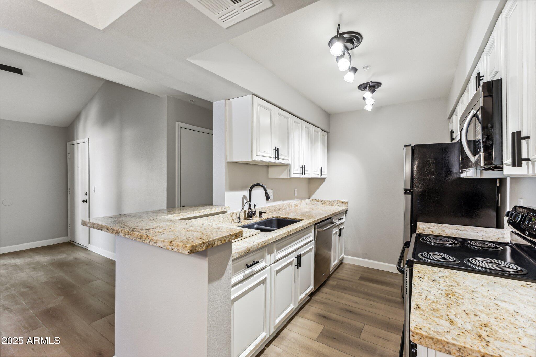 10610 South 48th Street, Unit 2016 Phoenix, AZ 85044 - Photo 5 of 13 a kitchen with stainless steel appliances granite countertop a sink stove and refrigerator