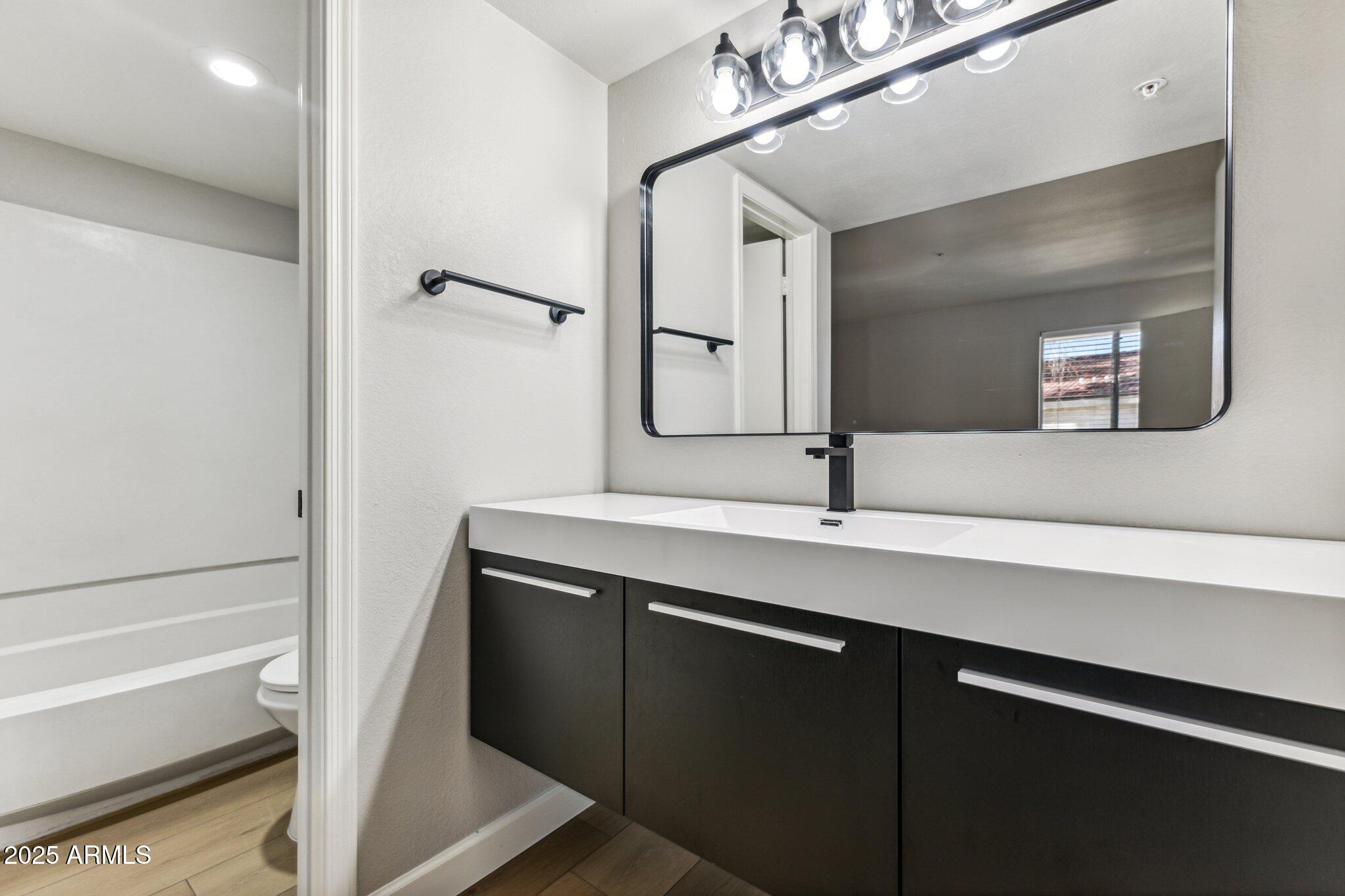 10610 South 48th Street, Unit 2016 Phoenix, AZ 85044 - Photo 8 of 13 a bathroom with a sink and a mirror