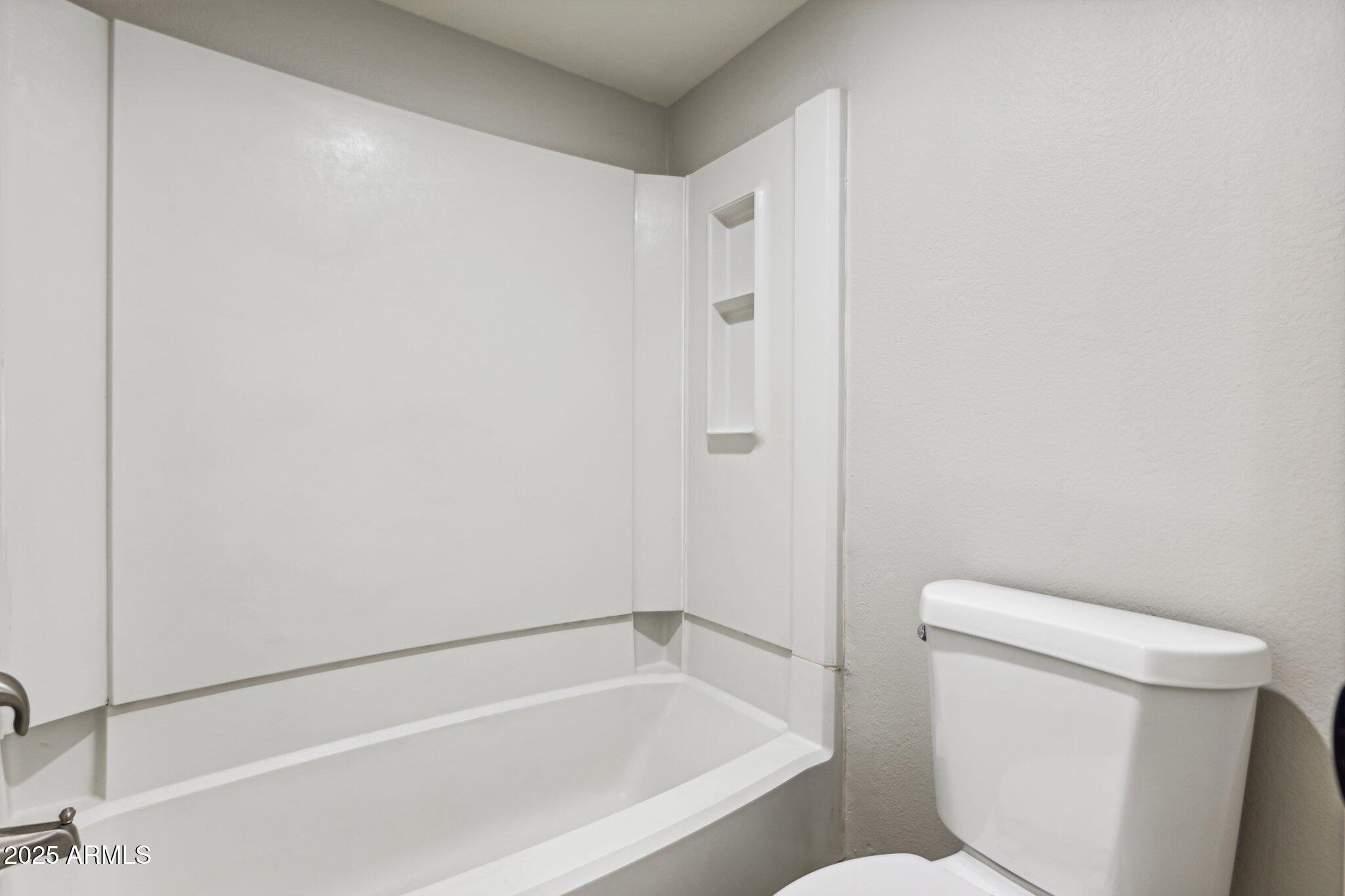 10610 South 48th Street, Unit 2016 Phoenix, AZ 85044 - Photo 9 of 13 a bathroom with a toilet and a bathtub