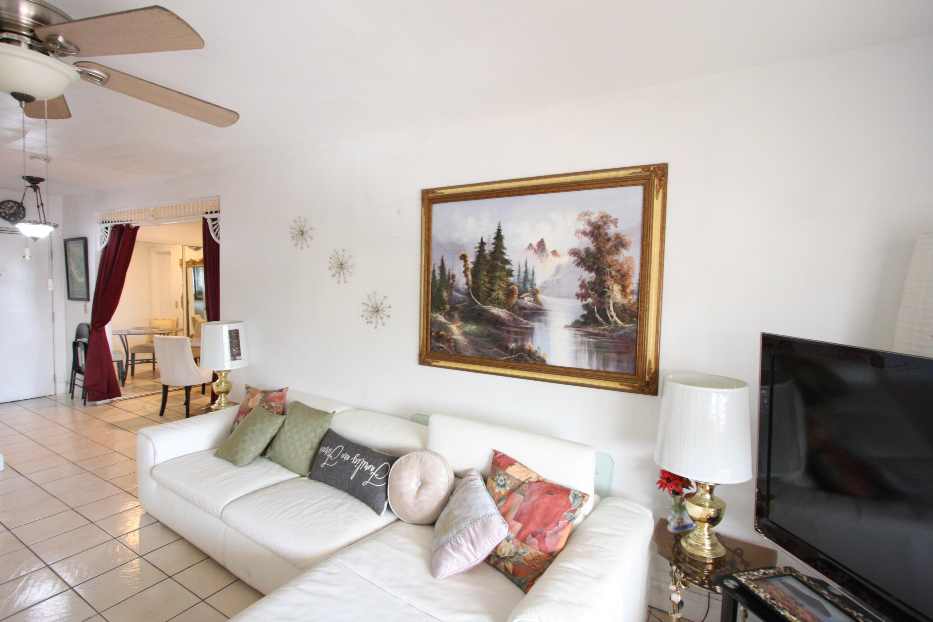 1050 East Sample Road, Unit 307 Pompano Beach, FL 33064 - Photo 1 of 28 a living room with furniture and a flat screen tv