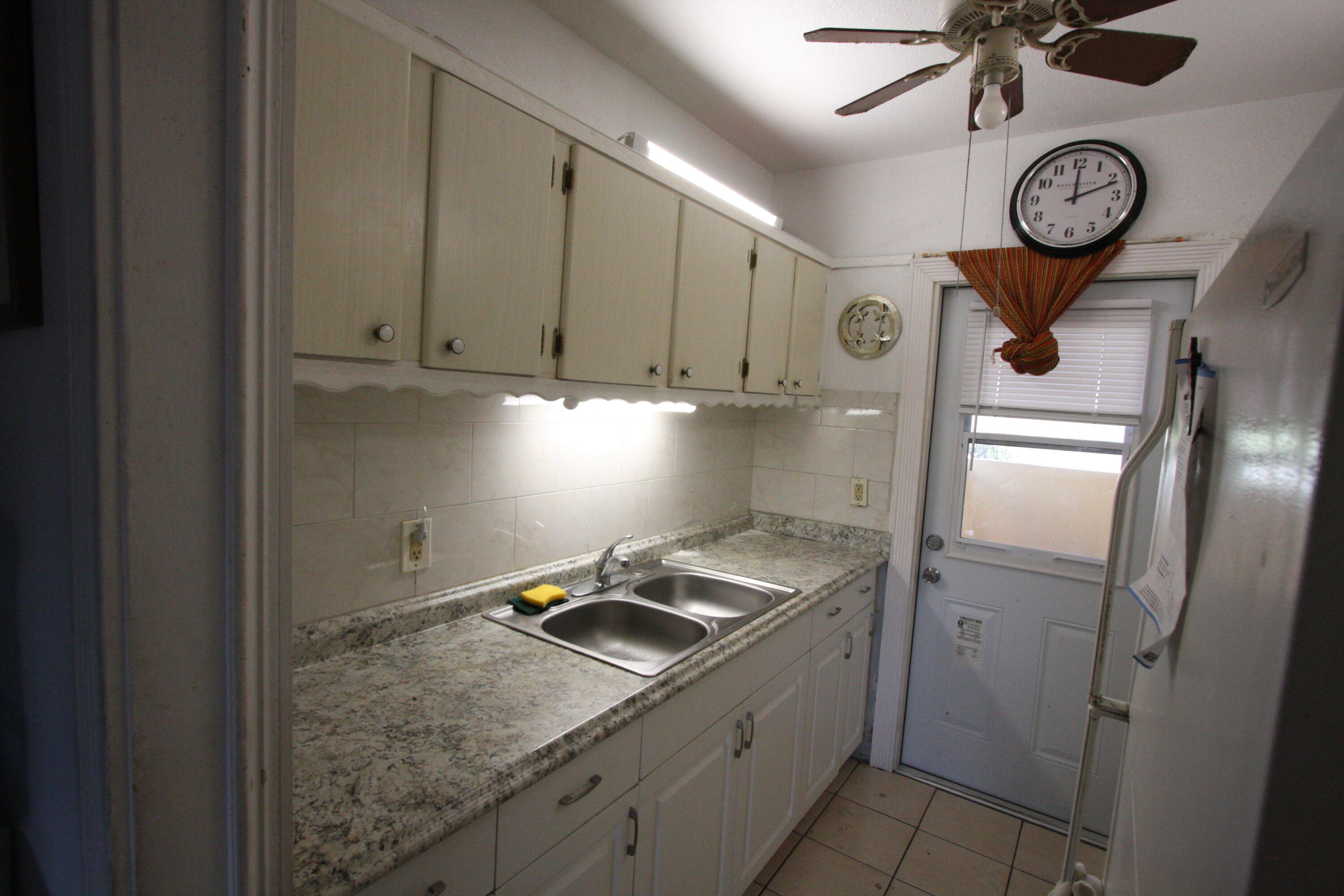 1050 East Sample Road, Unit 307 Pompano Beach, FL 33064 - Photo 17 of 28 a kitchen with a refrigerator a stove top oven and cabinets