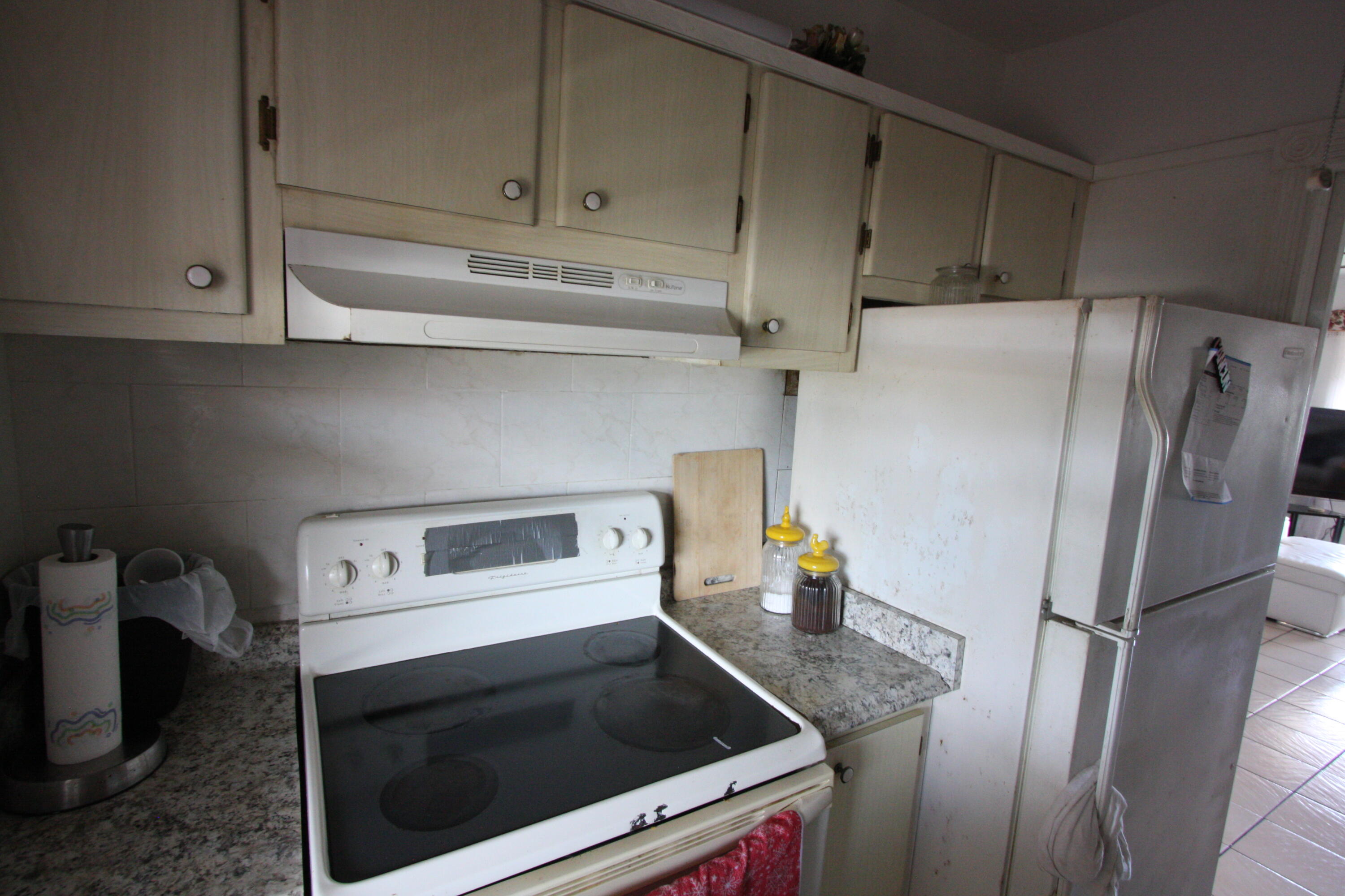 1050 East Sample Road, Unit 307 Pompano Beach, FL 33064 - Photo 22 of 28 a kitchen with refrigerator and cabinets