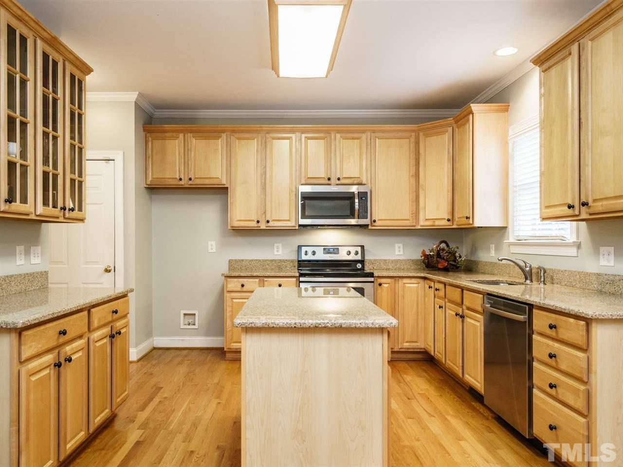 4408 Thistlehill Court Raleigh, NC 27616 - Photo 11 of 25 a kitchen with stainless steel appliances granite countertop a stove top oven a sink dishwasher and a refrigerator with wooden floor
