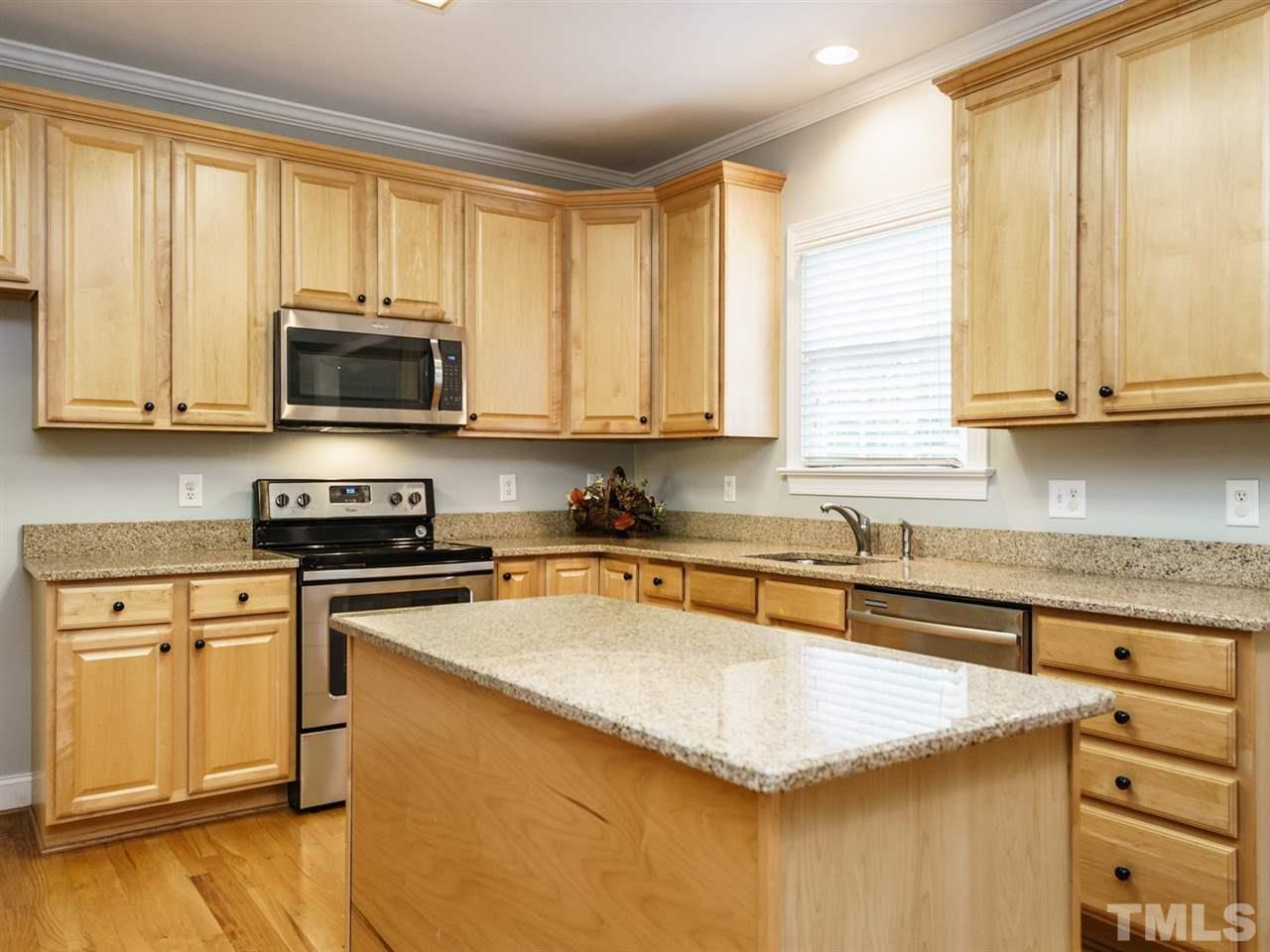 4408 Thistlehill Court Raleigh, NC 27616 - Photo 12 of 25 a kitchen with stainless steel appliances granite countertop a stove a sink and a microwave