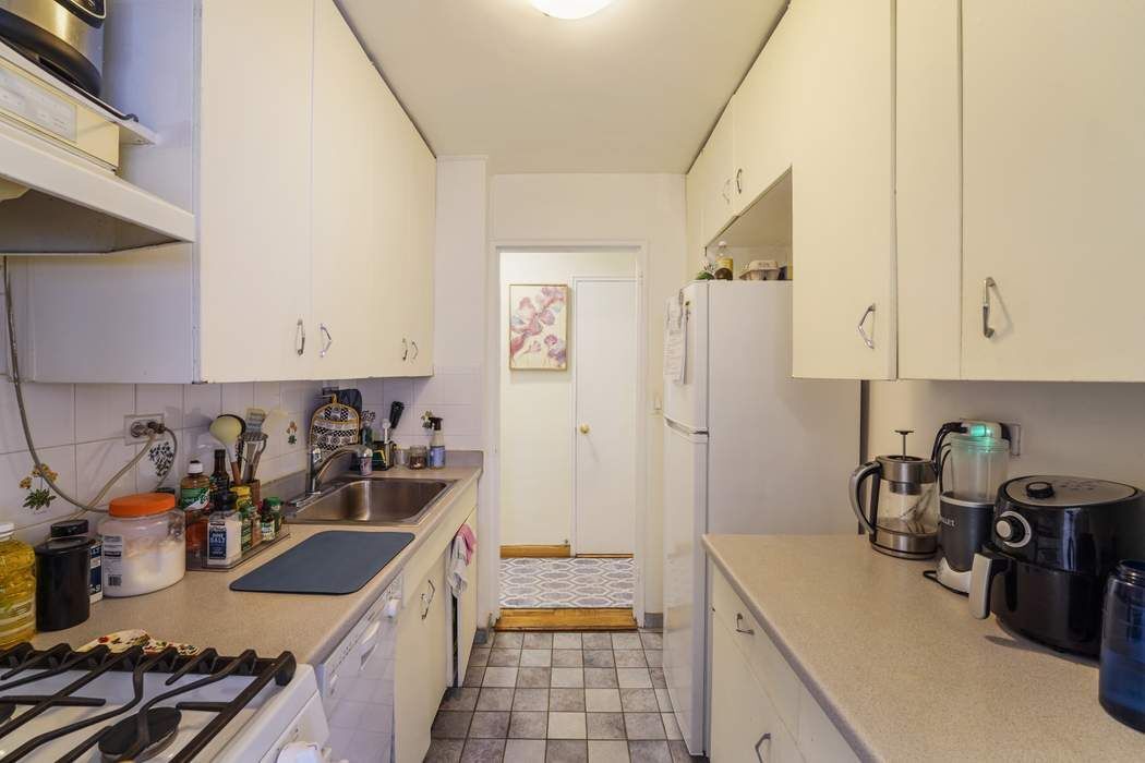 Undisclosed Address Manhattan, NY 10065 - Photo 5 of 10 a kitchen with a sink stove and cabinets