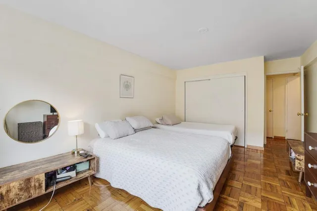 a bedroom with two beds and a large window