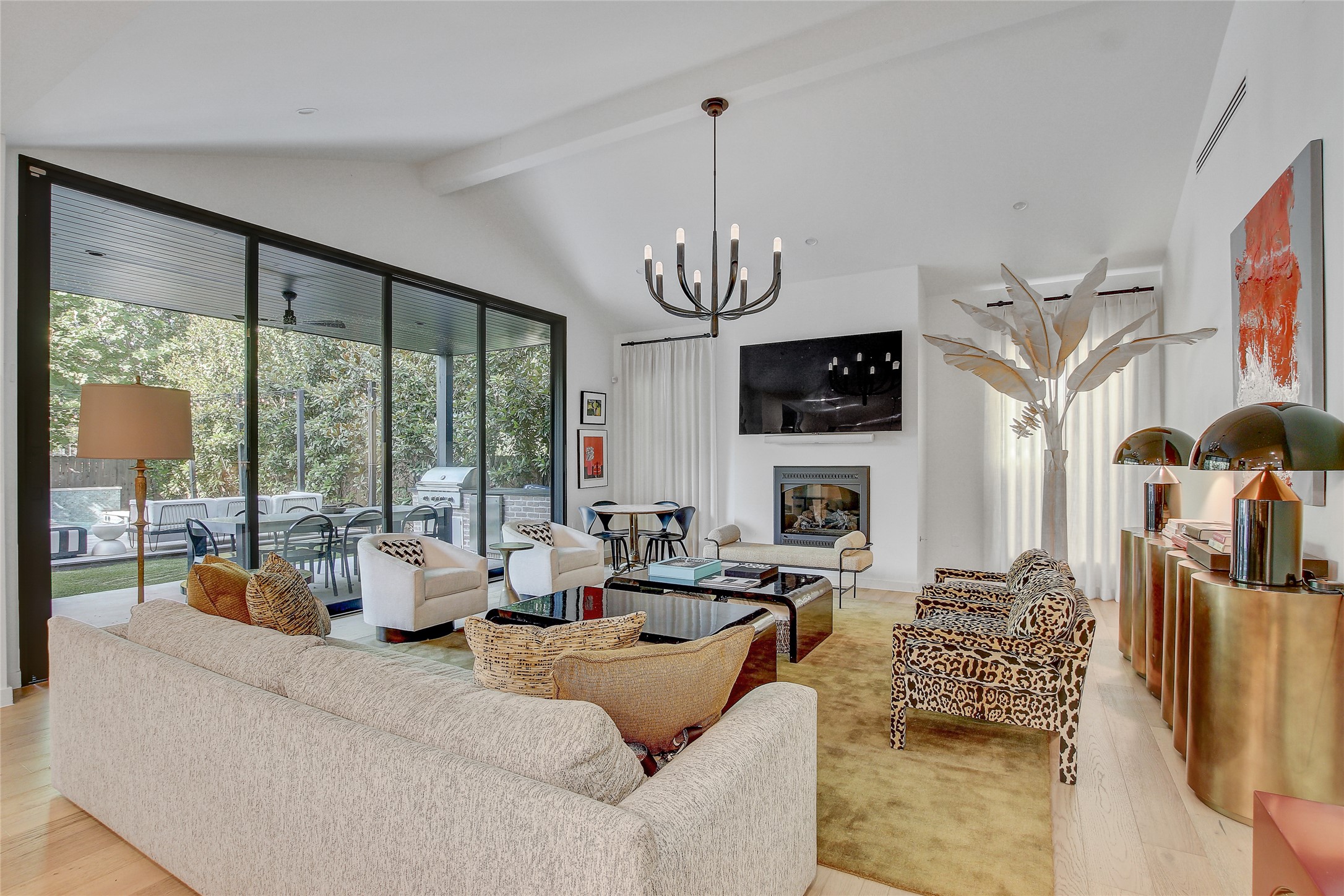 2006 Ford Street Austin, TX 78704 - Photo 4 of 40 Living room with beamed ceiling, light wood finished floors, a glass covered fireplace, a chandelier, and high vaulted ceiling