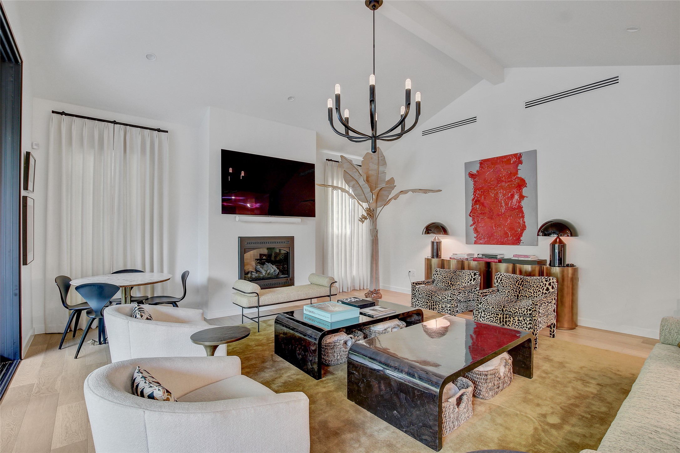 2006 Ford Street Austin, TX 78704 - Photo 5 of 40 Living room with wood finished floors, beam ceiling, a chandelier, high vaulted ceiling, and a glass covered fireplace