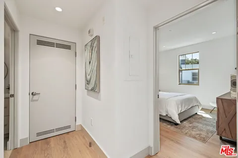 a view of a bedroom with wooden floor and hallway