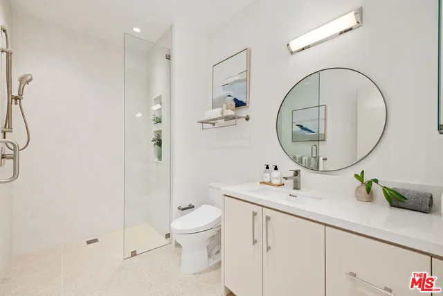 a bathroom with a sink a toilet and a mirror