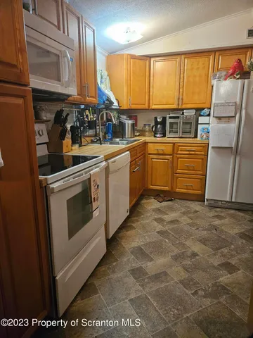 a kitchen with stainless steel appliances a stove a sink and white cabinets
