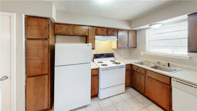 a kitchen with a refrigerator sink stove and cabinets