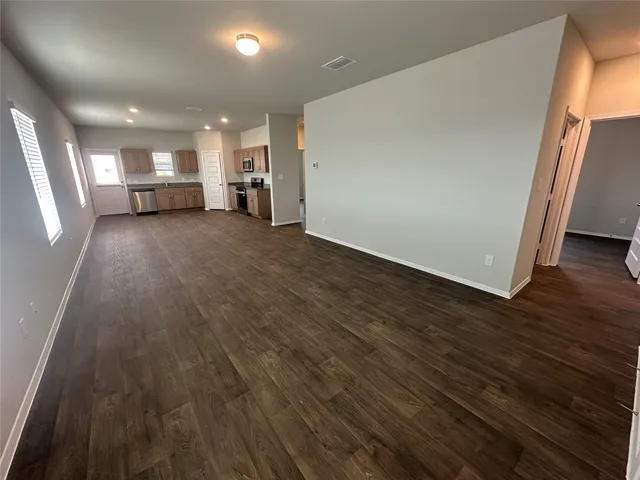 a kitchen with stainless steel appliances kitchen island granite countertop a sink cabinets and wooden floor