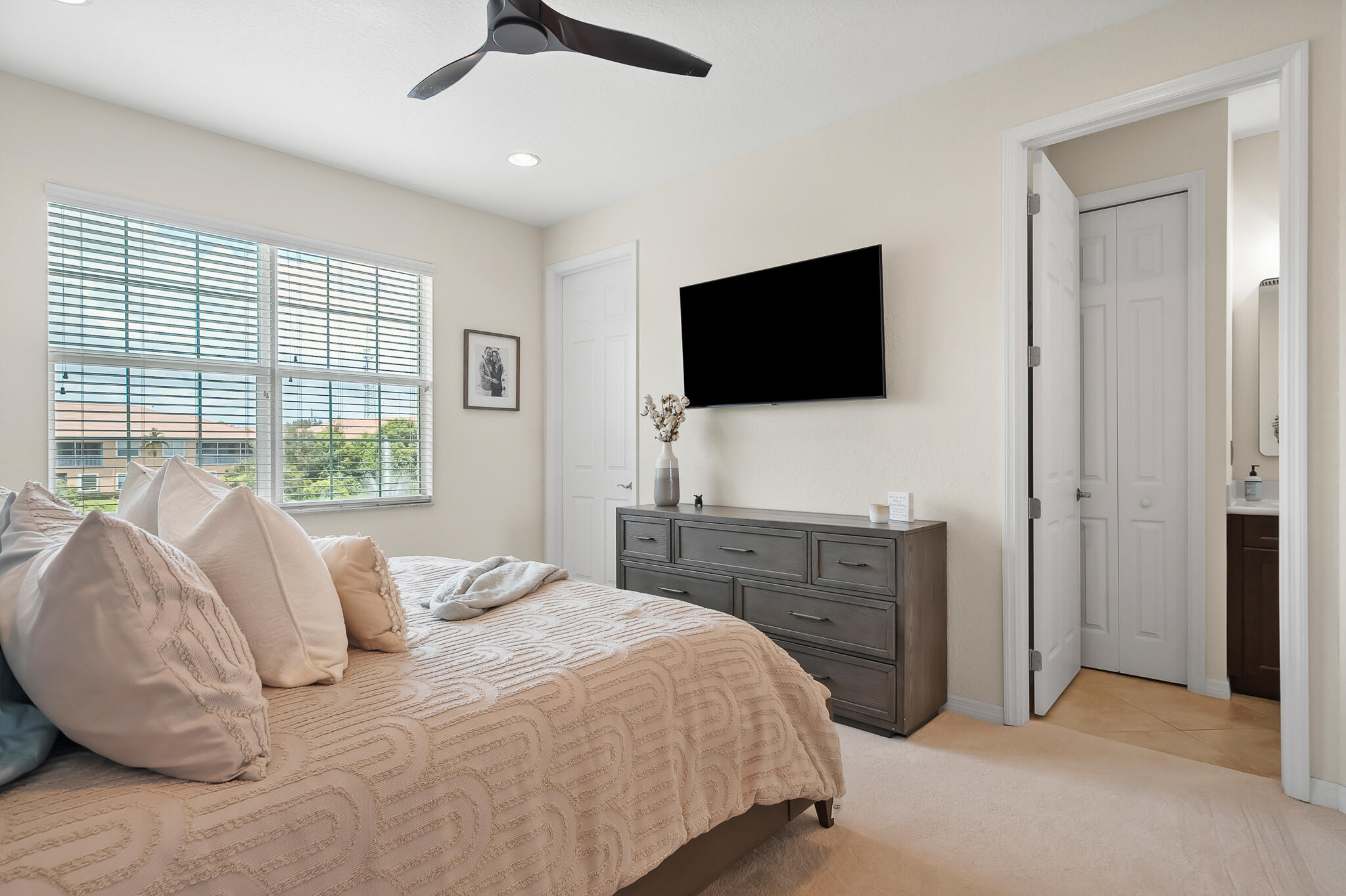 524 Southwest Glen Crest Way Stuart, FL 34997 - Photo 26 of 43 a bedroom with a bed and a flat screen tv