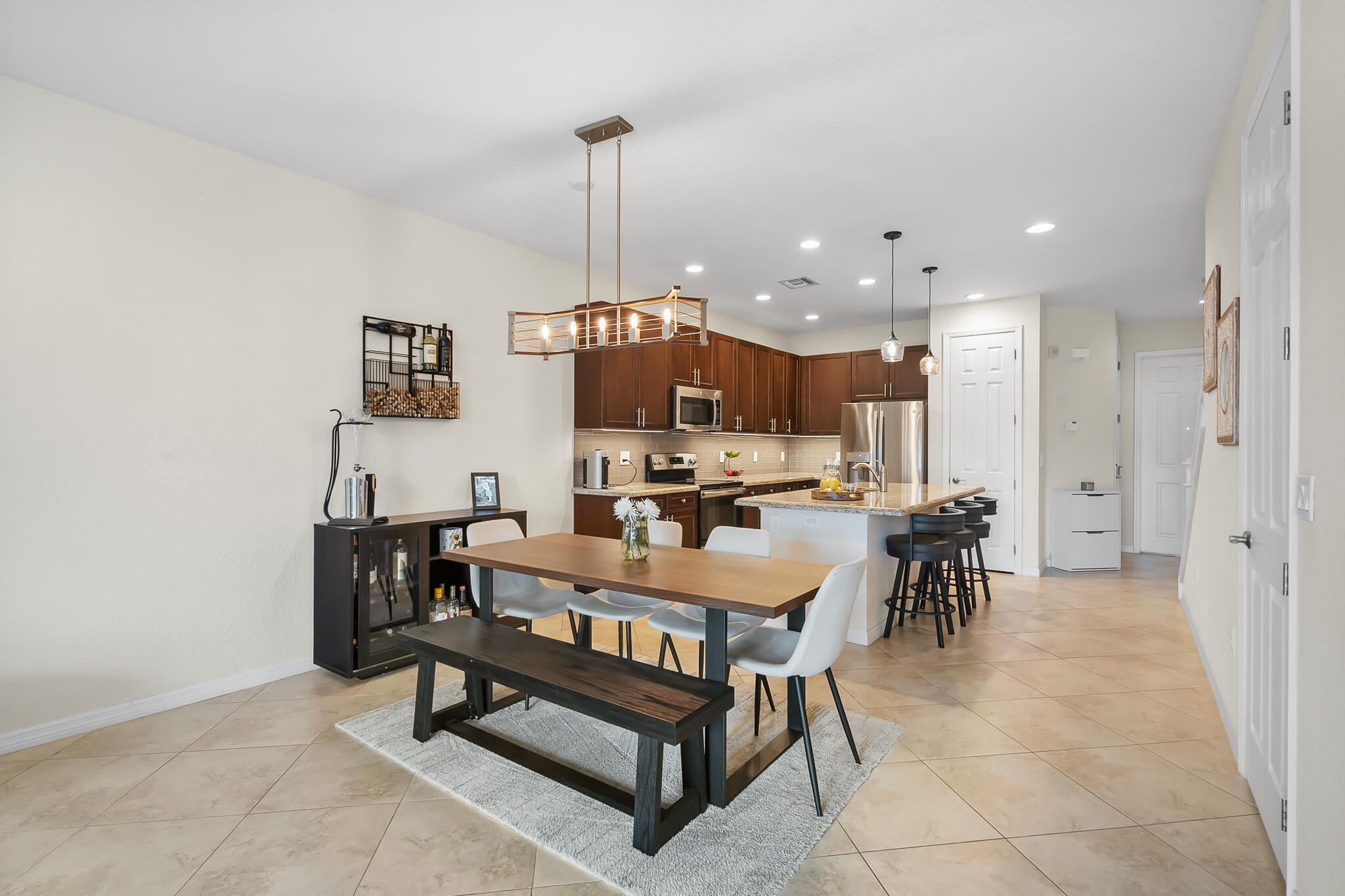 524 Southwest Glen Crest Way Stuart, FL 34997 - Photo 8 of 43 a view of a a dining room and livingroom with furniture wooden floor a rug a flat screen tv and a painting