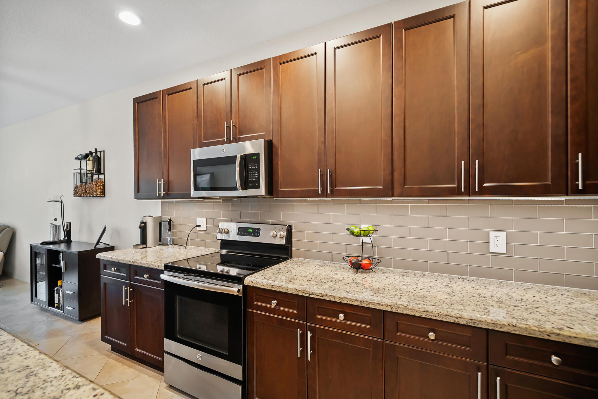 524 Southwest Glen Crest Way Stuart, FL 34997 - Photo 9 of 43 a kitchen with stainless steel appliances granite countertop a sink a stove microwave and cabinets