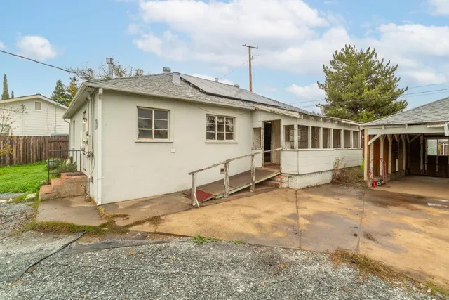 a view of a house with backyard and a tree