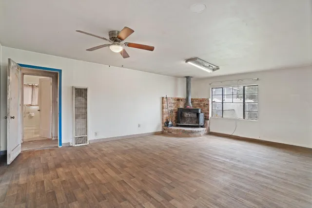 a view of empty room with wooden floor and ceiling fan