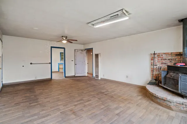 a view of empty room with a fireplace and wooden floor