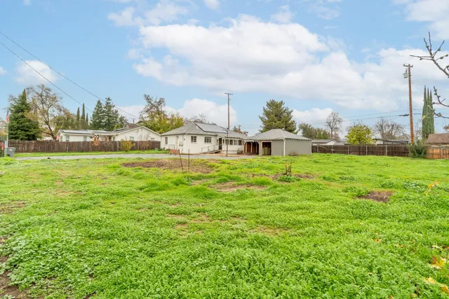a swimming pool with lawn chairs and a big yard