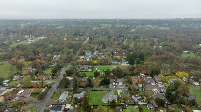 an aerial view of house with yard and mountain view in back