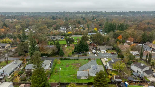 an aerial view of residential houses with outdoor space and trees