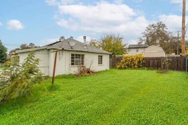 a view of an house with backyard space and balcony