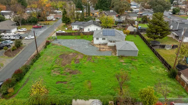 an aerial view of residential houses with outdoor space and trees