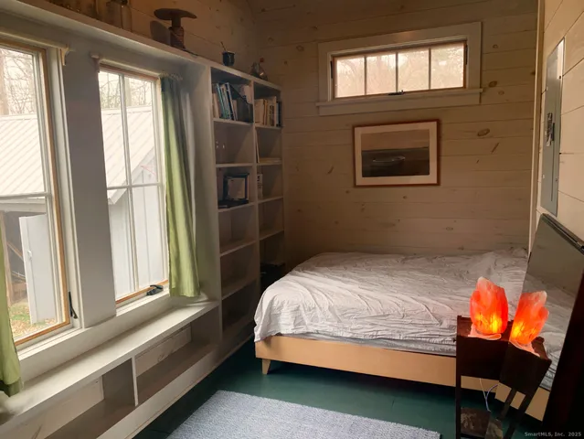 a bed sitting in a bedroom next to a window