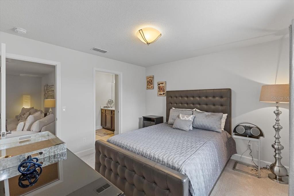 7180 Beek Street Windermere, FL 34786 - Photo 20 of 33 a bedroom with a bed and a chandelier