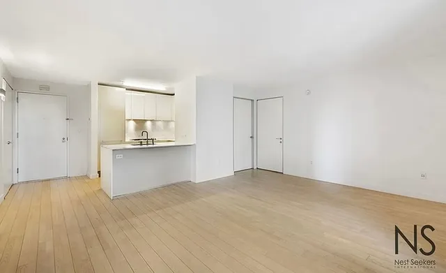 a kitchen with a sink cabinets stainless steel appliances and a window