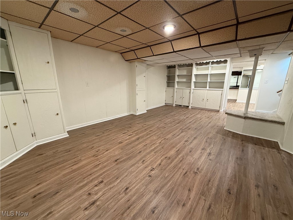 522 North 3rd Street Toronto, OH 43964 - Photo 38 of 47 Unfurnished living room with dark wood-style flooring, built in shelves, and a paneled ceiling