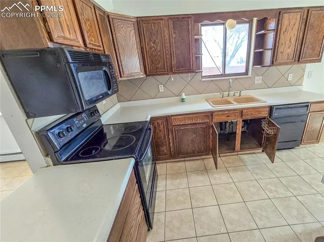 a view of a kitchen with furniture and a refrigerator