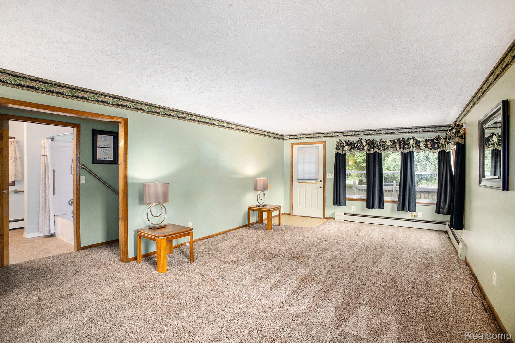 16568 28 Mile Road Albion, MI 49224 - Photo 4 of 26 Unfurnished room with crown molding, a textured ceiling, carpet, and baseboard heating